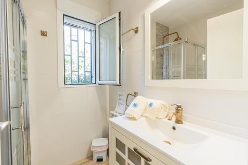 a white bathroom with a sink and a mirror at Kalacandi in Cunit