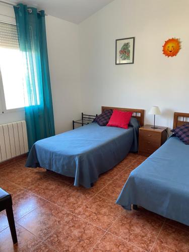 una camera da letto con due letti e una finestra di Chalet con gran jardin y piscina privada a Peñíscola
