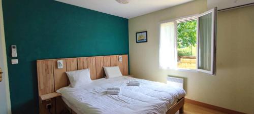 Ce lit se trouve dans une chambre dotée d'un mur vert. dans l'établissement La Londonniere, à Marcillac-Saint-Quentin