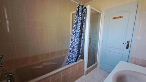 La salle de bains est pourvue d'une baignoire et d'un rideau de douche. dans l'établissement La Londonniere, à Marcillac-Saint-Quentin
