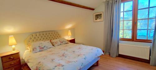 une chambre avec un lit et deux lampes et une fenêtre dans l'établissement La Maison au Bord du Lac, à Groléjac