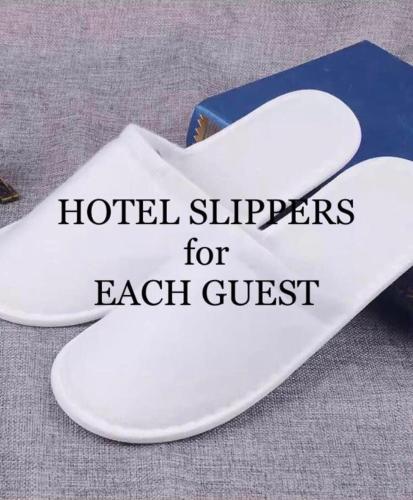 a book and white shoes with the words hotel slippers for each guest at Montalban GuestHouse 2 AC BR 4pax 200mbps WiFi FREE Netflix Shower Heater Parking in Rodriguez