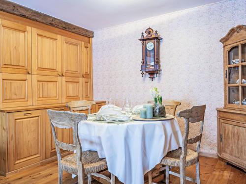 una sala da pranzo con tavolo, sedie e orologio di Apartment Chesa Olgiati 2 by Interhome a Celerina