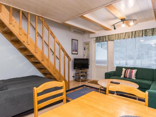 a living room with a green couch and a table at Holiday Home Kylpylän ullanrinne 12 d by Interhome in Ikaalinen