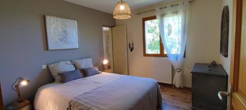 a bedroom with a large bed and a window at Le Refuge des libellules in Daglan