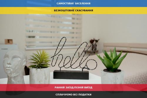 a table with two plants and a sign on it at Apartments at Kontorska 10 in Kharkiv