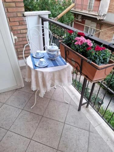 a balcony with a table and flowers on a balcony at Le chat bleu in Rome