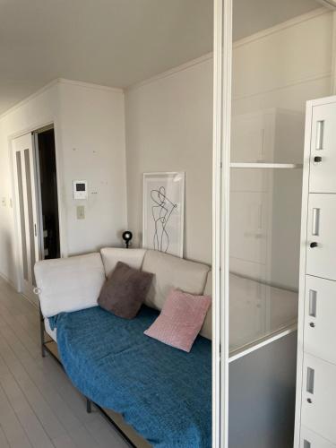 a living room with a couch and a mirror at Hostel 1010 TOKYO in Tokyo