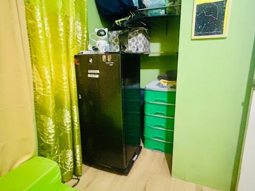 a kitchen with a black refrigerator in a room at Montalban GuestHouse 2 AC BR 4pax 200mbps WiFi FREE Netflix Shower Heater Parking in Rodriguez