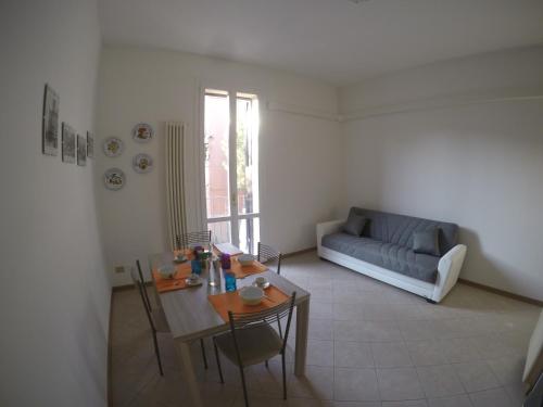 sala de estar con mesa y sofá en Corner Apartment en Bolonia