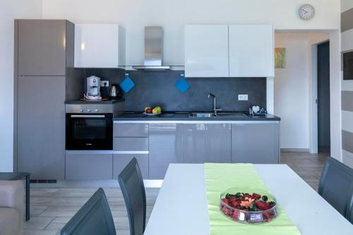 Una cocina con una mesa con un bol de fruta encima. en La Collinetta Lake View, en Vercana