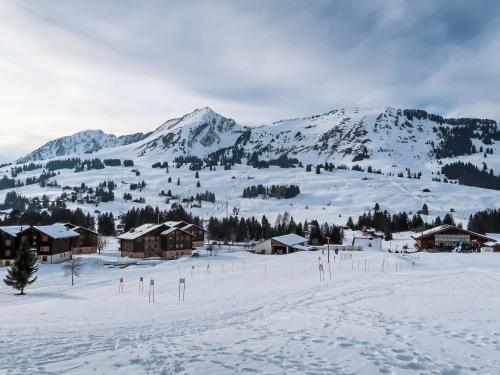 a snow covered mountain with houses and a ski slope at Apartment Les Bluets by Interhome in Les Mosses