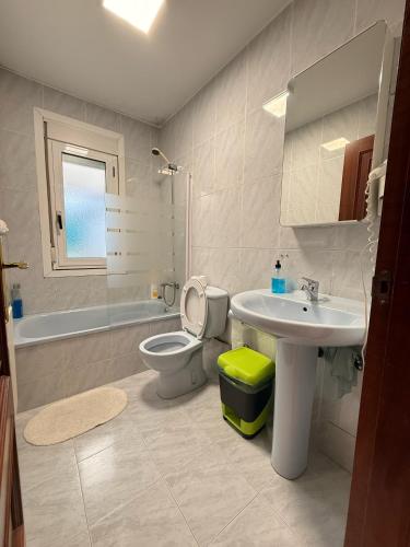 a bathroom with a sink and a toilet and a sink at Apartamentos Portolux in Portomarin