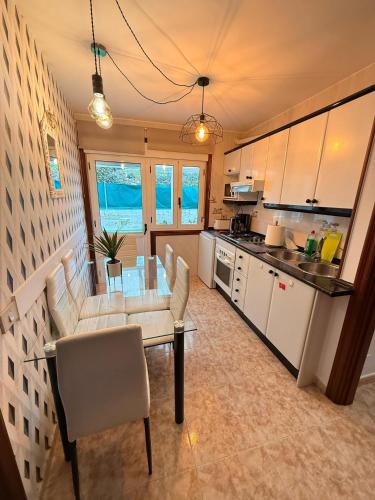a kitchen with a table and chairs in a room at Apartamentos Portolux in Portomarin