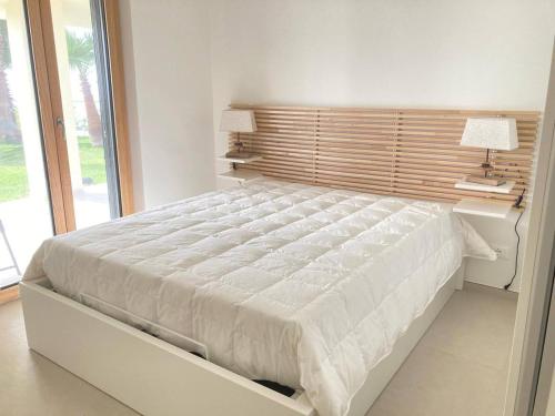 a bedroom with a large white bed with a window at Villa Jolanda - Costa degli Dei in Zambrone