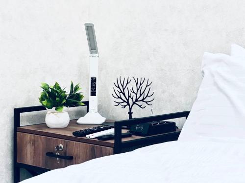 comodino con termometro e piante sopra di Smart City APARTMENT a Samarkand