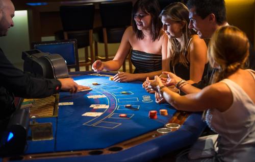 a group of people sitting around a casino roulette table at Mercure Namur Hotel in Namur