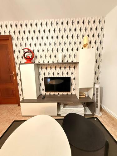 a living room with a fireplace with a wall at Apartamentos Portolux in Portomarin