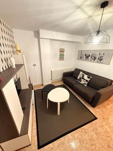 a living room with a couch and a table at Apartamentos Portolux in Portomarin