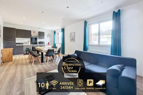 a living room with a blue couch and a kitchen at Apartment 10pers Aubière , Parking, WiFi - TV in Aubière