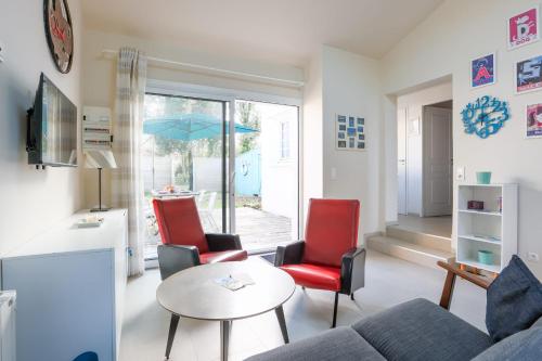 un salon avec un canapé, des chaises et une table dans l'établissement Maison Fantasio - Welkeys, à Dolus-d'Oléron