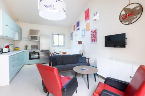 Il dispose d'une cuisine et d'un salon avec un canapé et une table. dans l'établissement Maison Fantasio - Welkeys, à Dolus-d'Oléron