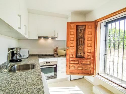 une cuisine avec une porte en bois et un évier dans l'établissement Holiday Home Colores al Mar by Interhome, à La Vila Joiosa