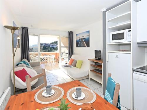 Il comprend une cuisine et un salon avec une table. dans l'établissement Apartment Village Cap Estérel - L'Esquinade-111 by Interhome, à Agay