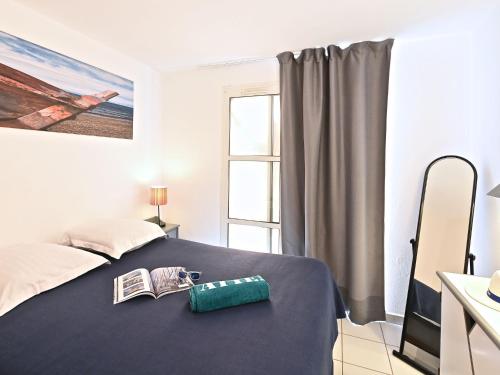 - une chambre avec un lit, un livre et une fenêtre dans l'établissement Apartment Village Cap Estérel - L'Esquinade-111 by Interhome, à Agay
