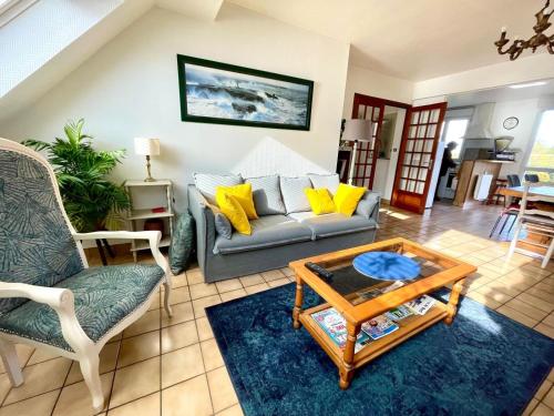 een woonkamer met een bank en een salontafel bij Maison de la plage Santec in Santec