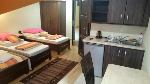 a small room with two beds and a kitchen at DW Poronianka in Poronin