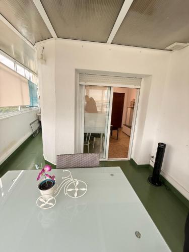 a room with a table with a plant on it at Apartamentos Portolux in Portomarin