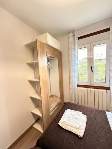a bedroom with a mirror and a bed and a window at Apartamentos Portolux in Portomarin