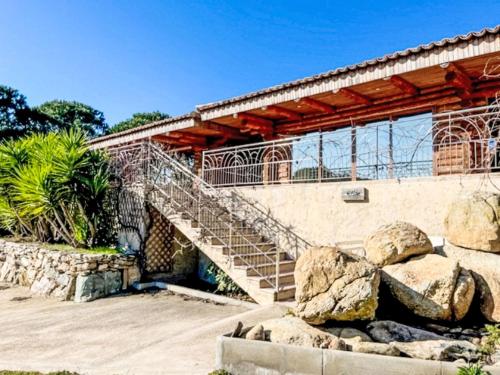 un escalier menant à un bâtiment avec des rochers dans l'établissement Holiday Home Chalet Double by Interhome, à Pietracorbara