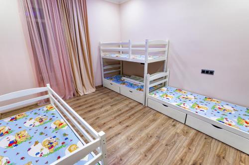 a bedroom with two bunk beds and wooden floors at Villa Ashtarak in Ashtarak