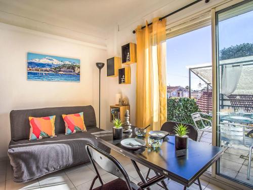un salon avec une table et un canapé dans l'établissement Apartment Nid d'Azur by Interhome, à Villeneuve-Loubet