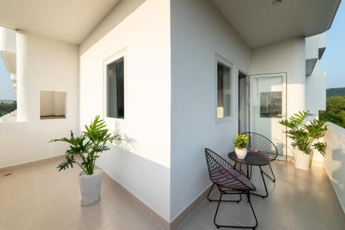 a balcony with two chairs and a table with plants at The Up Hotel Phu Quoc Island - The Poolside Escape in Phu Quoc