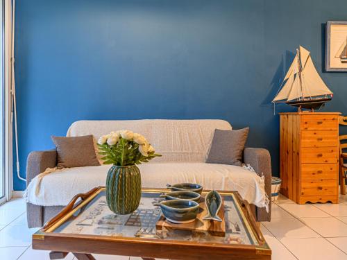 un salon avec un canapé et une table avec des fleurs dans l'établissement Apartment Clair de lune-2 by Interhome, à Carnac