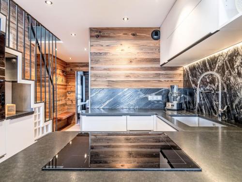 - une cuisine avec des murs en bois et des appareils en acier inoxydable dans l'établissement Apartment Le Curling B - Val Claret-43 by Interhome, à Tignes