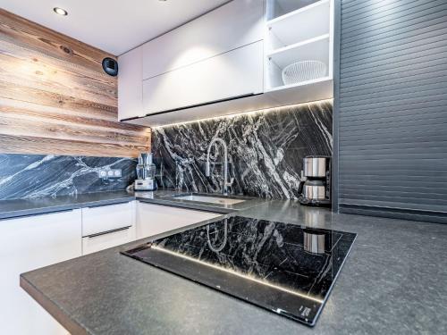 - une cuisine avec des placards blancs et des comptoirs en marbre noir dans l'établissement Apartment Le Curling B - Val Claret-43 by Interhome, à Tignes