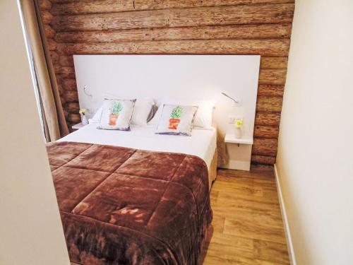 - une chambre avec un lit et un mur en bois dans l'établissement Holiday Home U Castellu by Interhome, à Pietracorbara