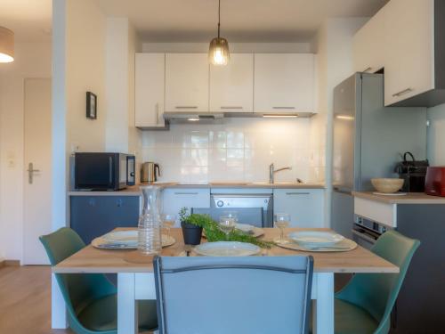 une cuisine avec une table en bois et des chaises ainsi qu'une salle à manger dans l'établissement Apartment Les Berges Landaises-6 by Interhome, à Capbreton