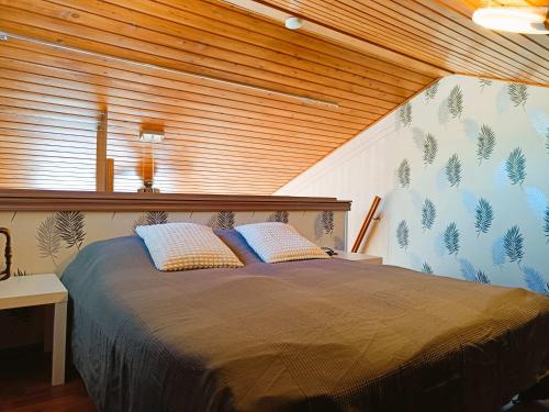 Un dormitorio con una cama grande con techo de madera. en Näköalahuoneisto 420, en Syöte
