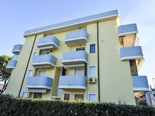 a yellow building with blue balconies on it at Apartment Mediterraneo-16 by Interhome in Rosapineta