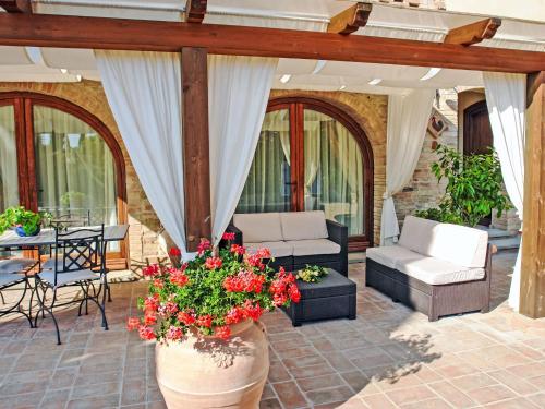 a patio with a couch and a table with flowers at Holiday Home La Vecchia Pieve by Interhome in Nebbiano
