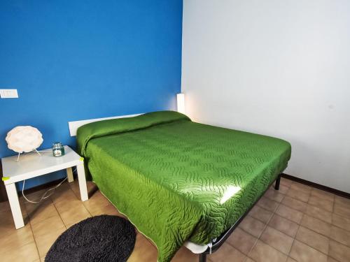 a green bed in a room with a table at Apartment Antony by Interhome in Rosapineta
