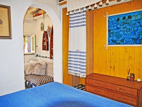 a bedroom with a blue bed and a chair at Villa Giulia by Interhome in Sperlonga