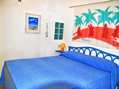 a blue bed in a bedroom with a painting on the wall at Villa Giulia by Interhome in Sperlonga