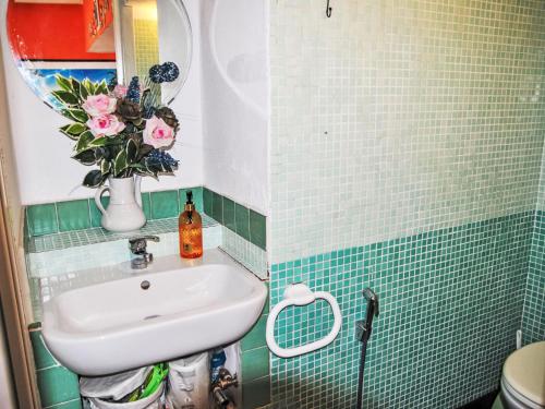 a bathroom with a sink and a vase of flowers at Villa Giulia by Interhome in Sperlonga