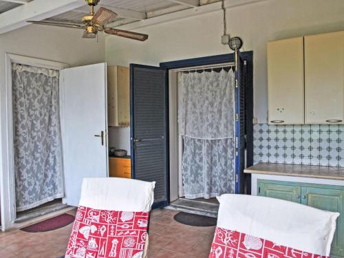 a kitchen with two white chairs in a room at Villa Giulia by Interhome in Sperlonga